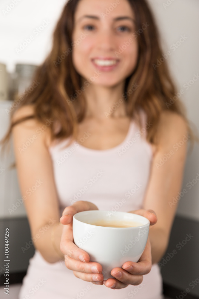 Woman showing a cup of coffee