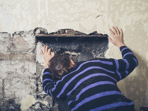 Young woman examinig fireplace photo