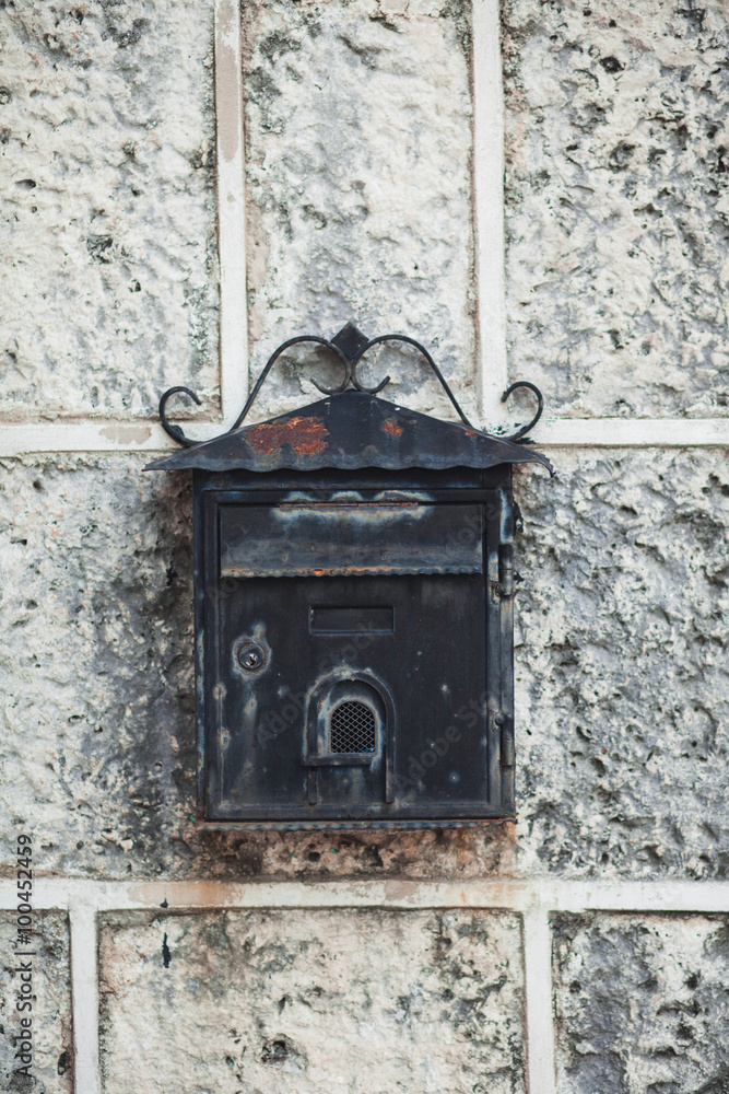 old black iron mailbox hanging on the wall