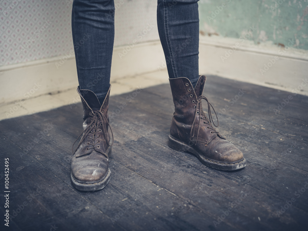Person wearing boots standing in empty room Person wearing boots standing in empty room