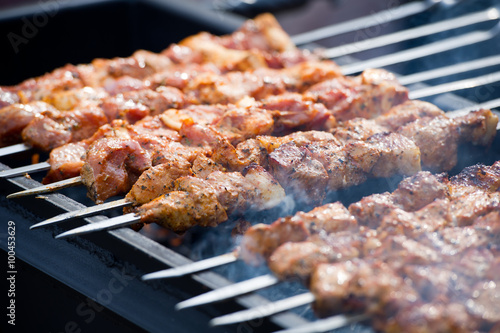 Grilling marinated shashlik on a grill. Shashlik is a form of Shish kebab popular in Eastern, Central Europe and other places. Shashlyk (meaning skewered meat) was originally made of lamb.
