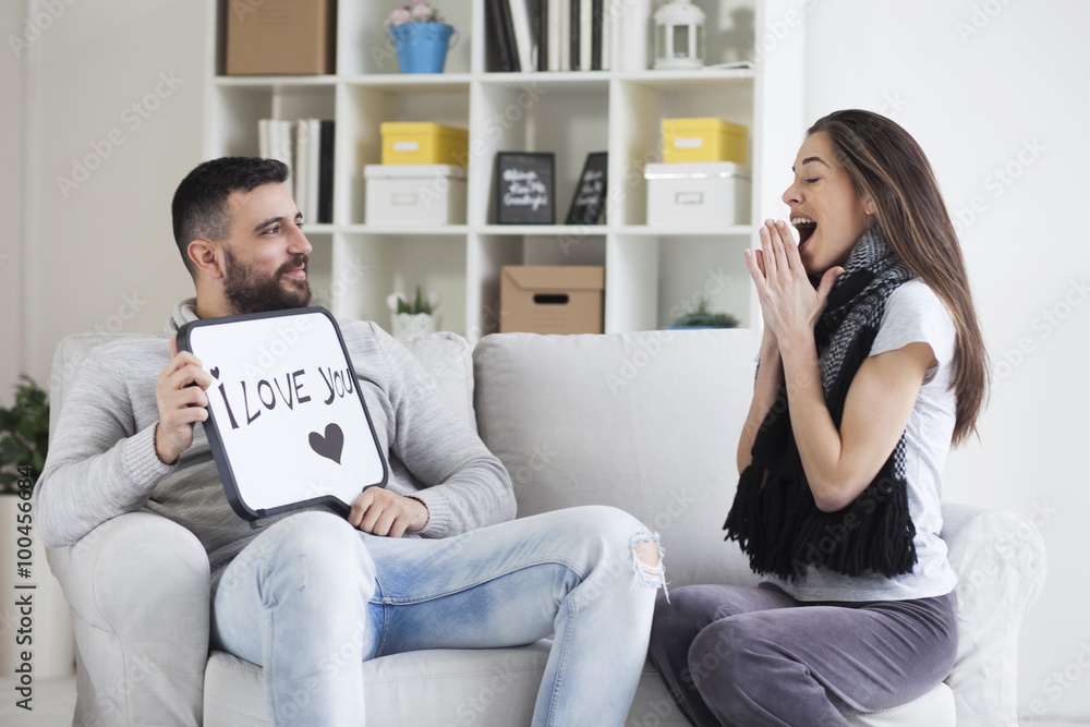 Young couple showing love message written on white board. I love you message. Valentines couple,shallow depth of filed Young couple showing love message written on white board. I love you message. Valentines couple,shallow depth of filed