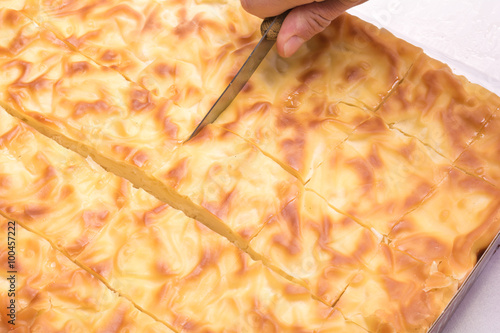 Hand cut with a knife traditional Bulgarian pie in pieces photo