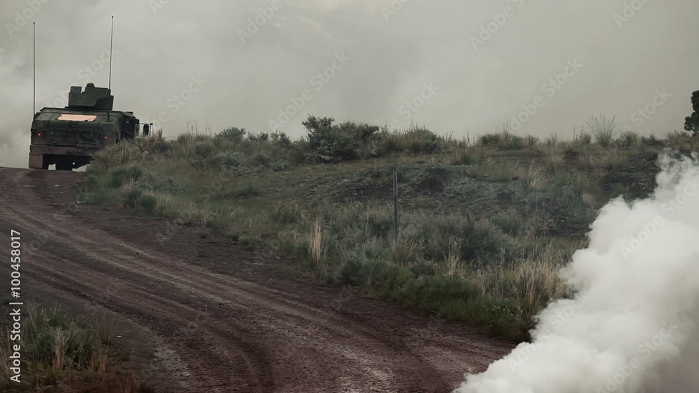 Two Humvees in a convoy drive on a dirt road. Two Humvees in a convoy drive on a dirt road.
