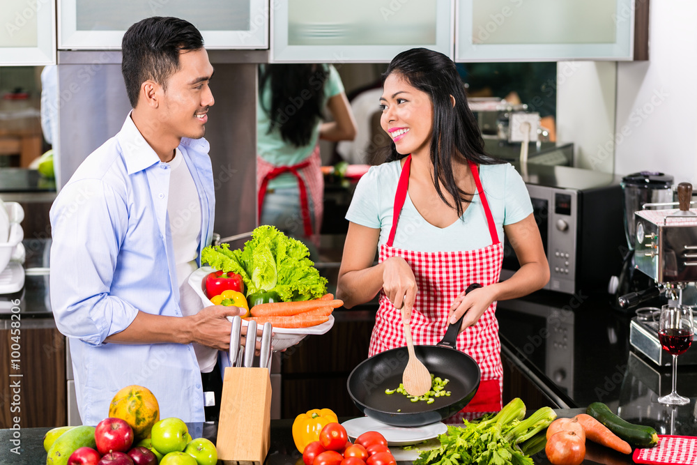 Asian man and woman cooking together Asian man and woman cooking together