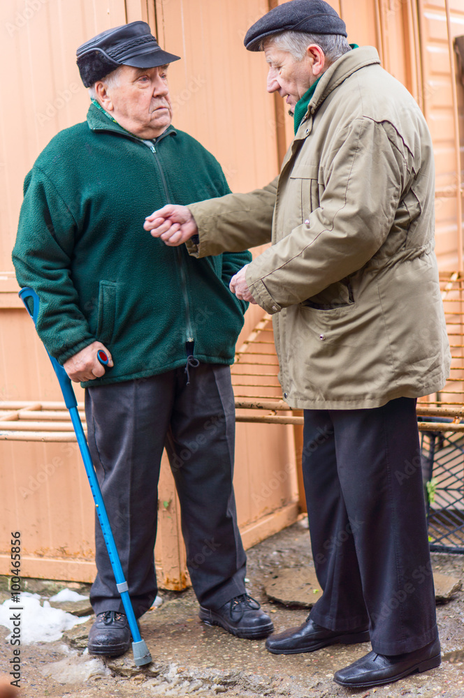 Two aged men discuss in the street Two aged men discuss in the street