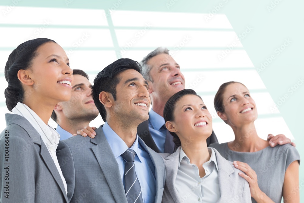 Composite image of business people looking up in office Composite image of business people looking up in office