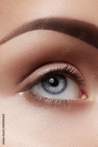Close-up macro of beautiful female eye with perfect shape eyebrows. Clean skin, fashion naturel make-up. Good vision