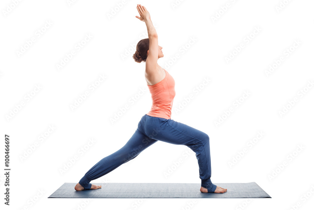 Woman practices yoga asana utthita Virabhadras