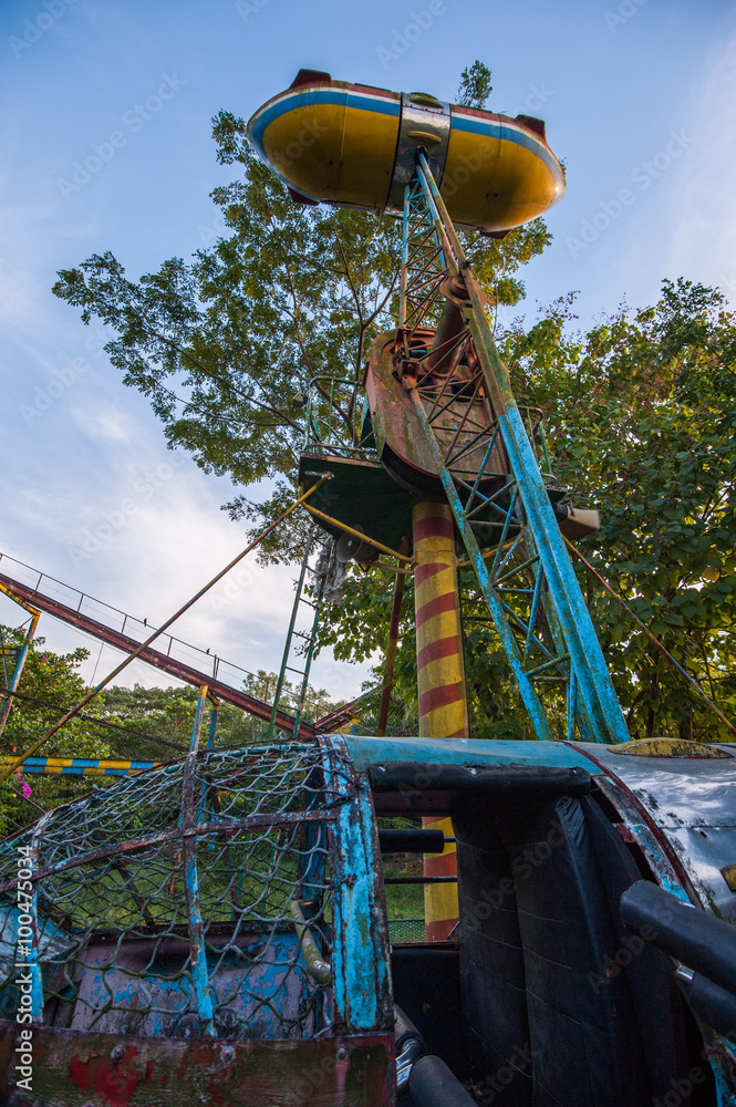 Rusty disused dive bomber fair ground ride at Yangon abandoned amusement park