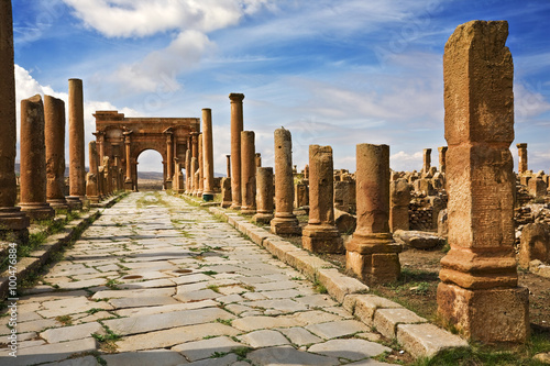 Algeria. Timgad (ancient Thamugadi or Thamugas). Decumanus Maximus street and surrounding colonnade terminated Trajan's Arch photo