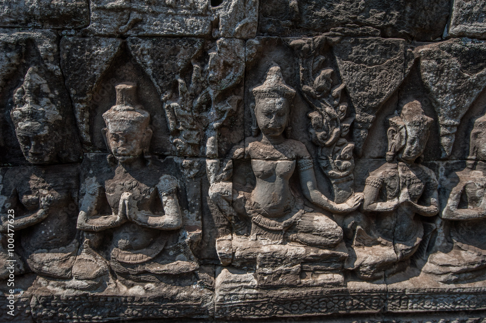 Carved stone figures on the wall at Bayon Temple, Angkor Wat, Cambodia