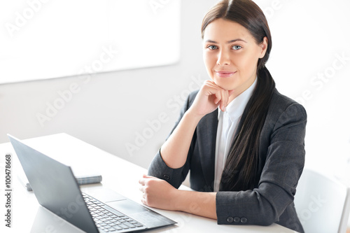 Portrait of young pretty business woman with laptop in the offic