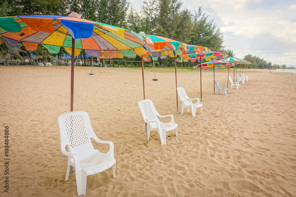 Beach chairs with colorful umbrella at the beach with blue-sky background on summer.