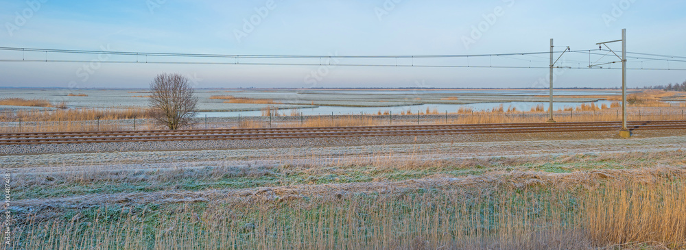 Railroad through sunny frozen nature in winter Railroad through sunny frozen nature in winter