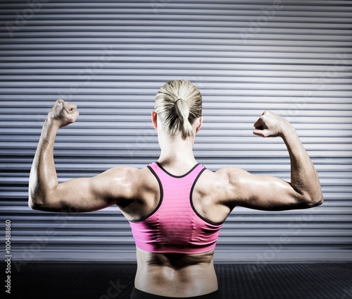 Composite image of muscular woman flexing her arms 