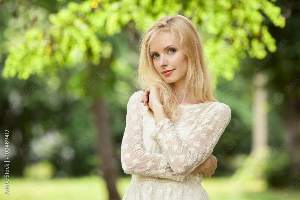 Beautiful young blond woman in a white dress outdoors Beautiful young blond woman in a white dress outdoors