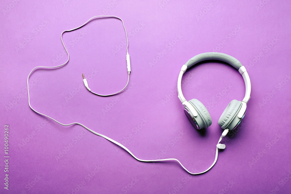 White and grey headphones on purple background White and grey headphones on purple background