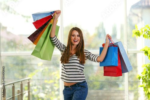 Young pretty woman with shopping packages in the shop