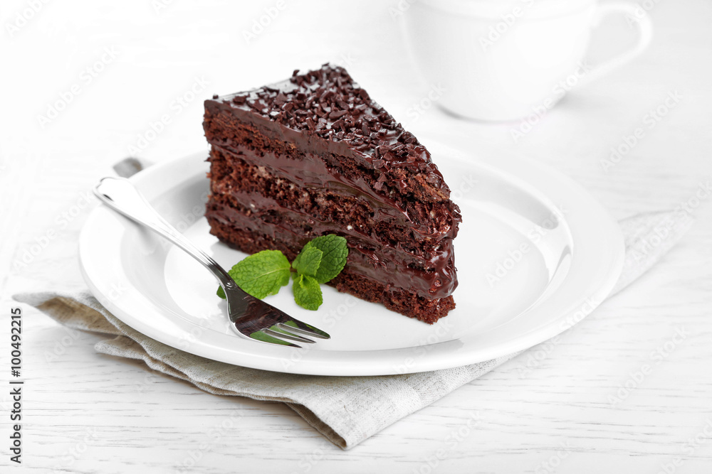 Chocolate cake with chocolate cream on plate, on light background Chocolate cake with chocolate cream on plate, on light background