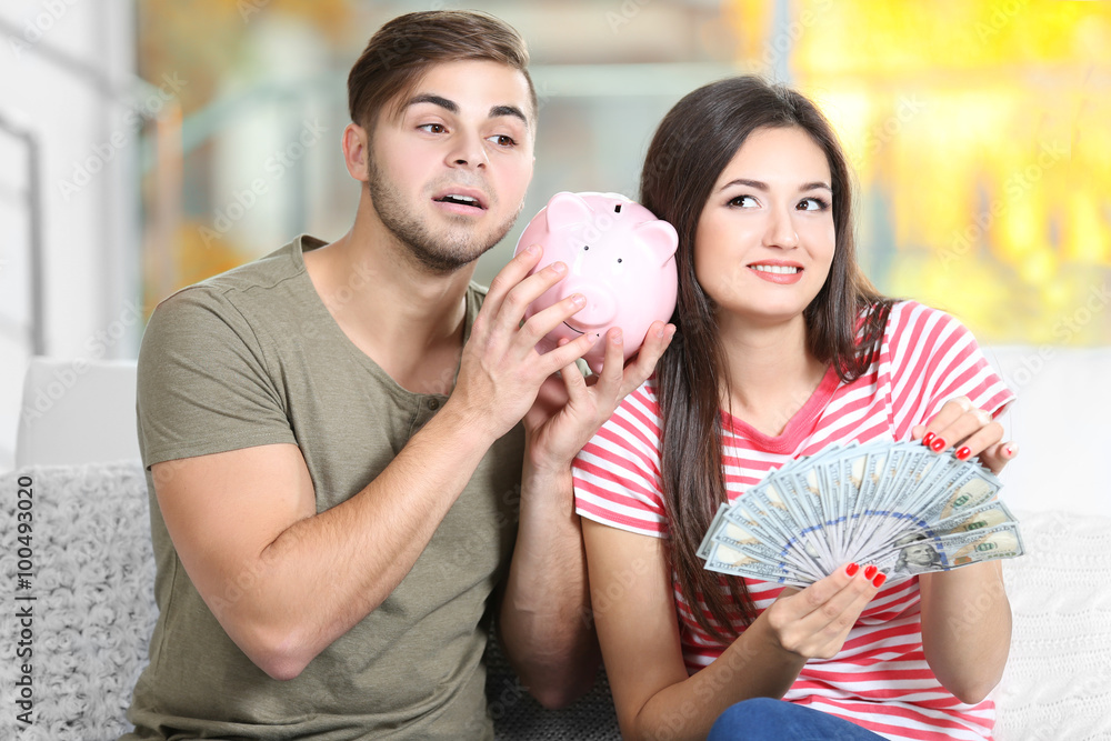 Fototapeta premium Happy couple with money from the moneybox