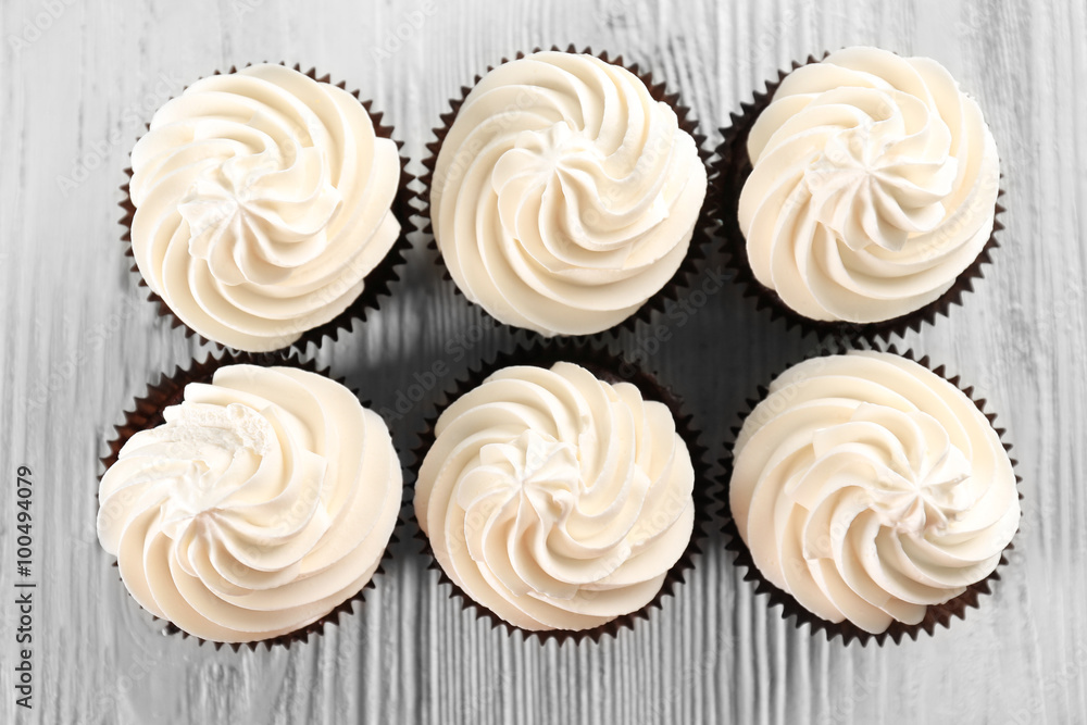 Tasty cupcakes on white wooden background, close up Tasty cupcakes on white wooden background, close up