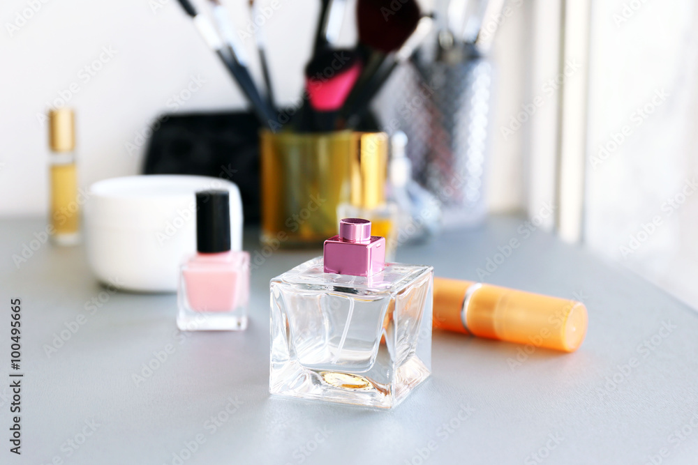 Perfume bottle with makeup tools and cosmetics on a table Perfume bottle with makeup tools and cosmetics on a table