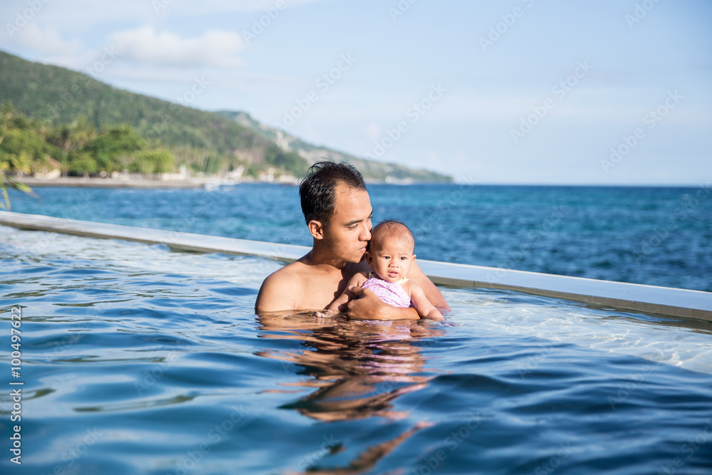 baby having fun in the swimming pool with mother