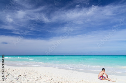 Young Asian playing on white sandy beach