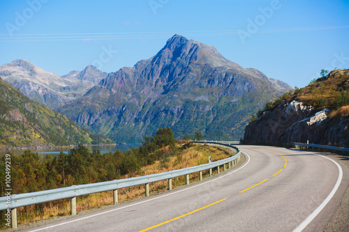 Picturesque Norway road landscape on high mountains, lake and fjord with blue sky in summer day, Norge.