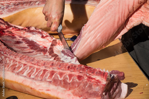Butcher hands on fresh pork