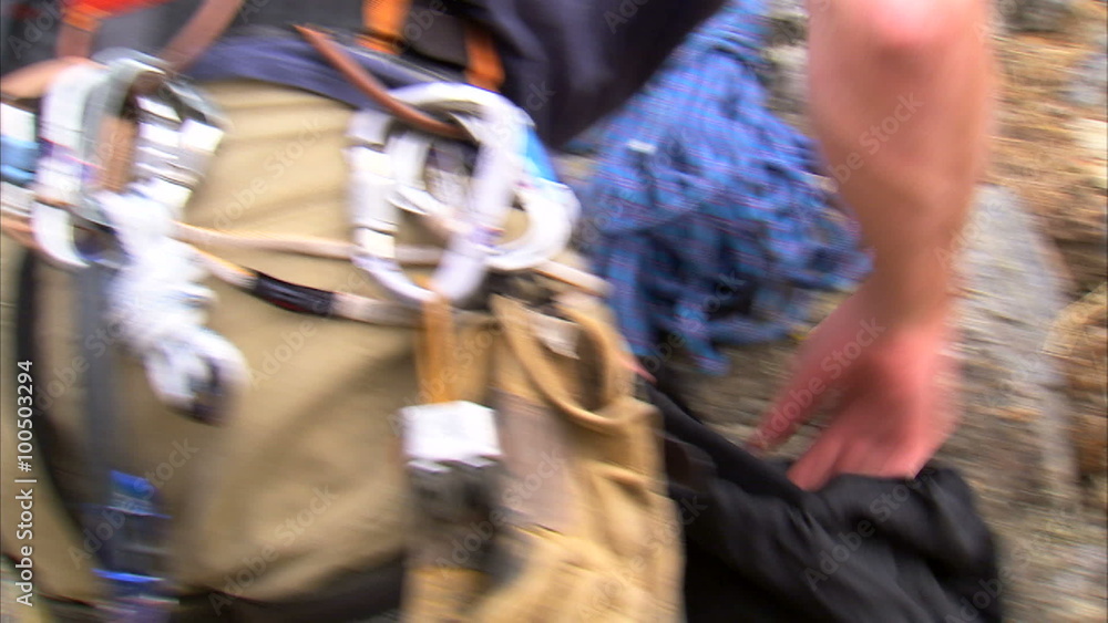 Mountain climber packing his pack with gear. Mountain climber packing his pack with gear.