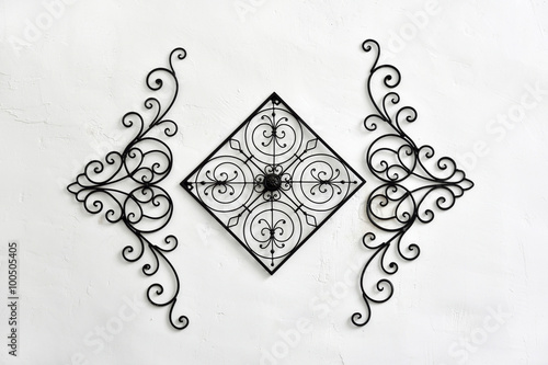 Decorative wrought iron hanging on the white wall photo