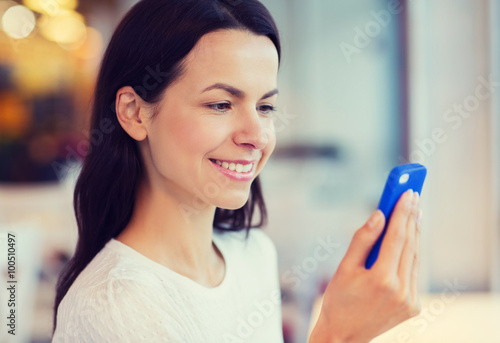 close up of smiling woman with smartphone at cafe