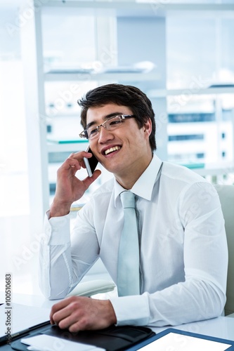 Smiling asian businessman talking on the phone