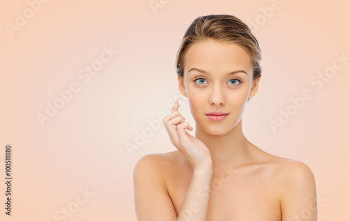 young woman applying cream to her face