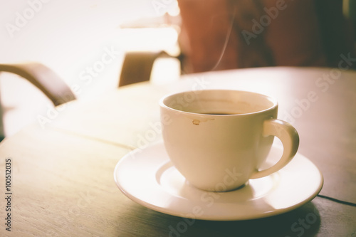 Cup of coffee on wooden table vintage color