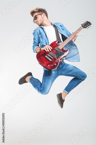 Tapety artystyczne guitar player jumping while playing rock and roll