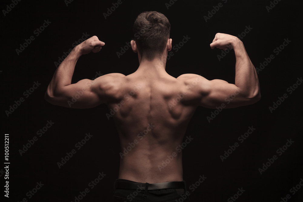 rear view of topless muscular man posing in studio rear view of topless muscular man posing in studio
