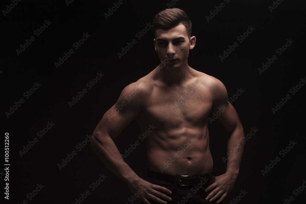 topless muscular guy posing in dark studio background topless muscular guy posing in dark studio background