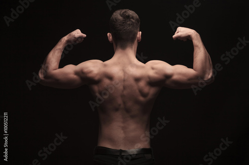rear view of topless muscular man posing in studio