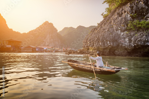 Woman in boat returns to fishing village, Ha Long Bay, Vietnam