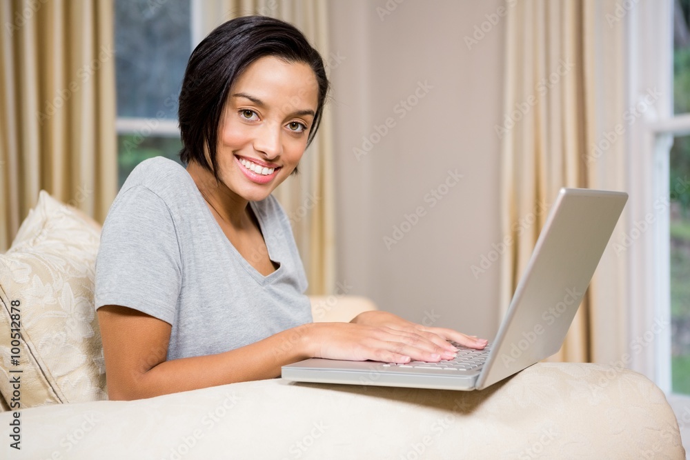 Smiling brunette using laptop