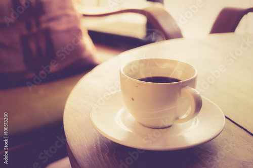 Cup of coffee on wooden table vintage color