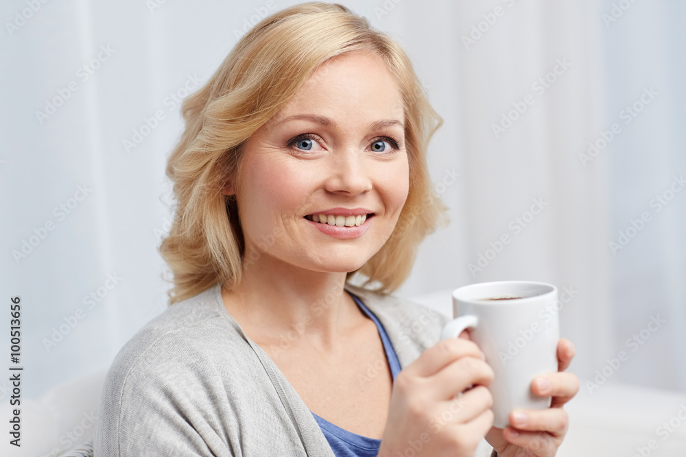 smiling woman with cup of tea or coffee at home smiling woman with cup of tea or coffee at home