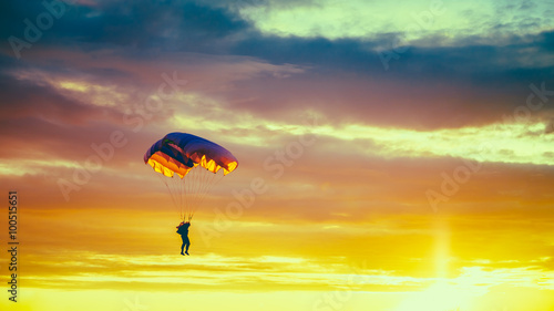 Photo Skydiver On Colorful Parachute In Sunny Sunset Sky. Active Hobbi