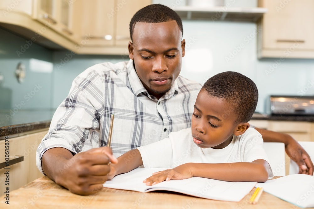 Father helping son for homework Father helping son for homework
