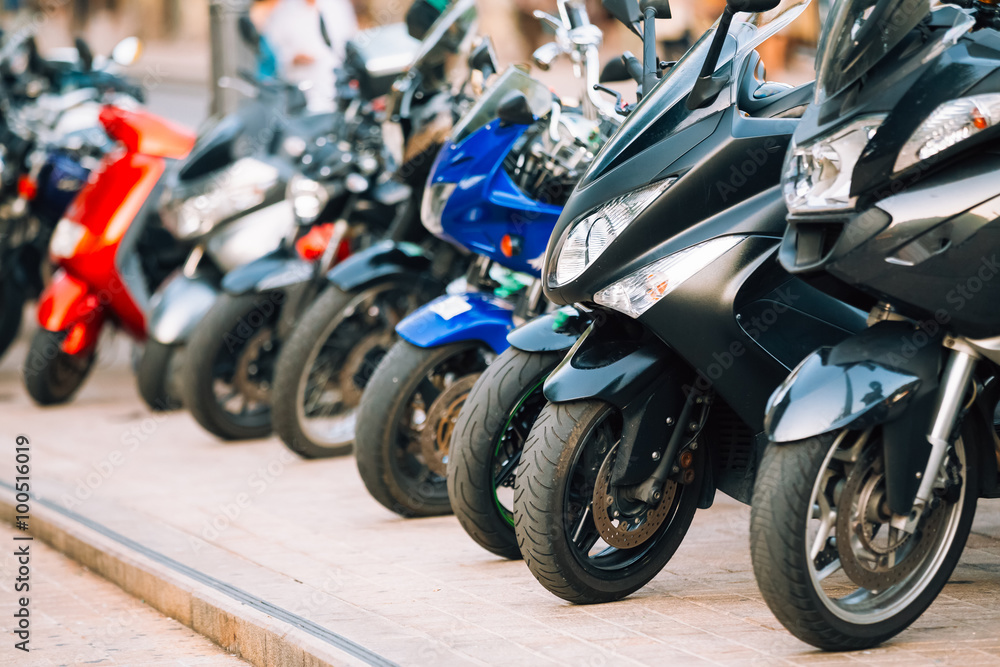 Naklejka premium Motocykl, skutery motocyklowe zaparkowane w rzędzie na ulicy miasta