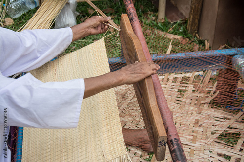 Woman weaving silk in traditional way at manual loom. Thailand