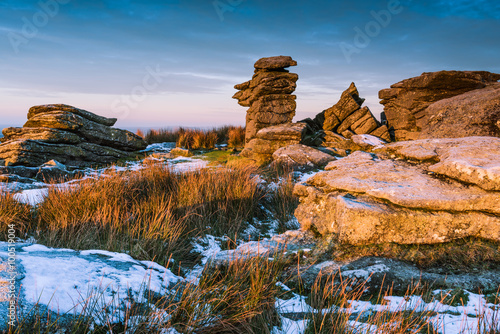 Spectacular sunrise on rocky hill mountain at snowy morning photo